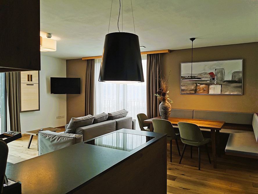Panorama Living Dolomites: Die Küchenzeile ist hochwertig ausgestattet und am großen Esstisch gibt es viel Platz für gemeinsame Genussmomente.