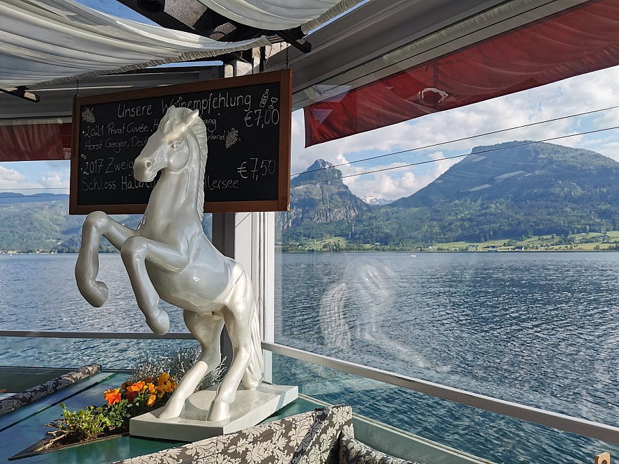 Im Weissen Rössl: Blick vorbei an einer Weissen Rössl Statue auf den Wolfgangsee